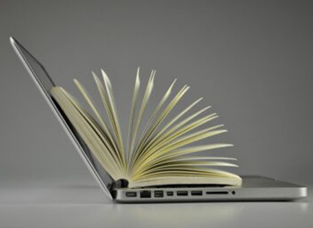 Laptop and pages of an open book